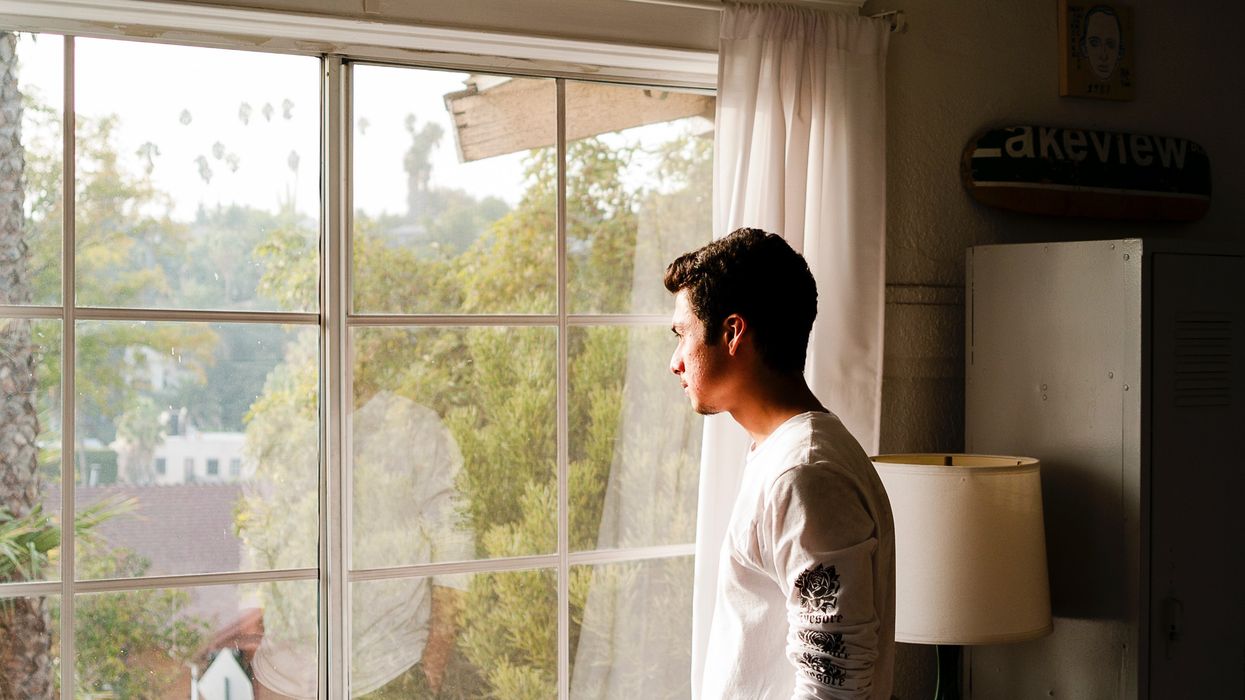 Man looking out window