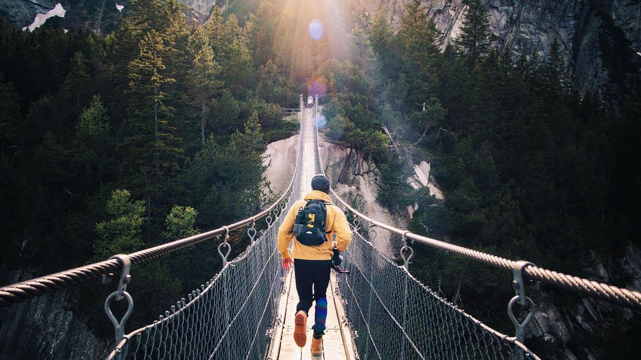 Man running across suspended walking bridge