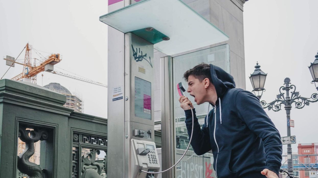 Man screaming into payphone