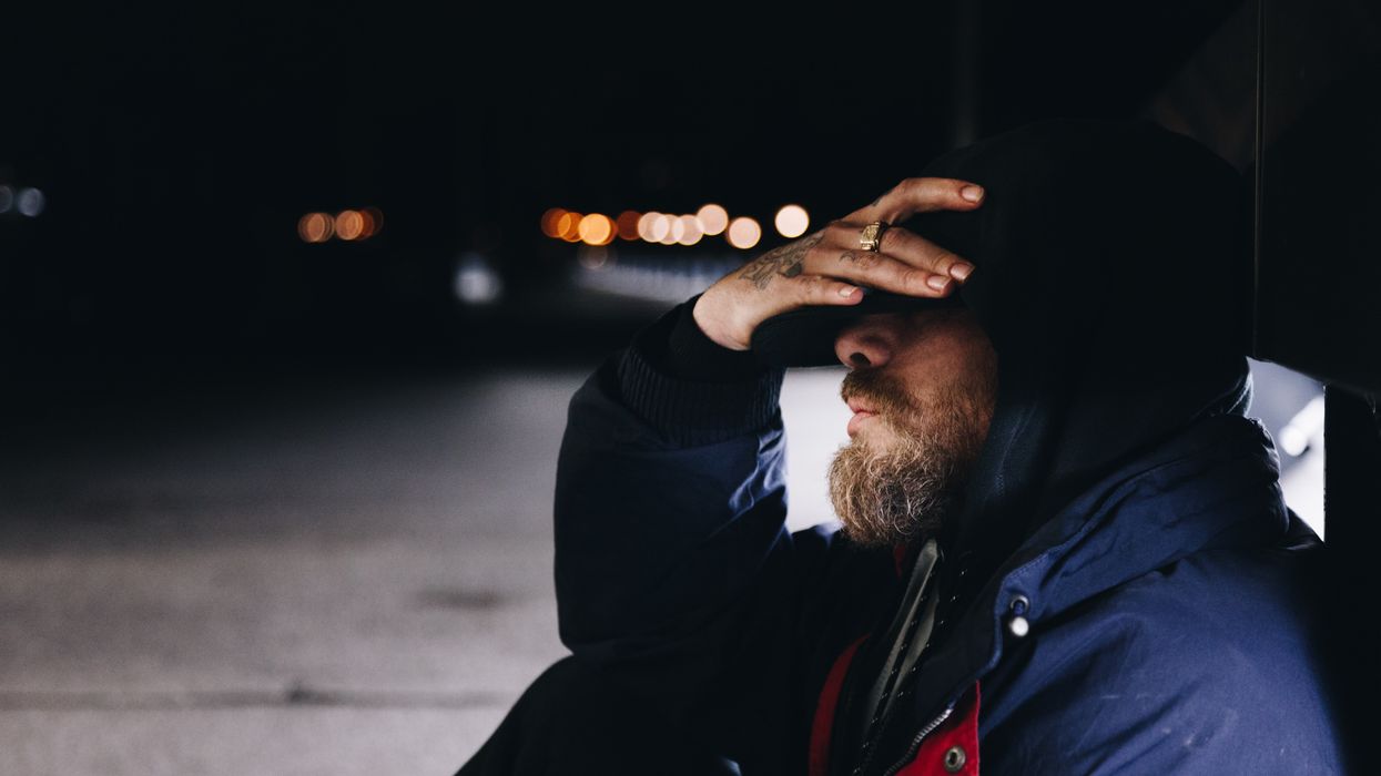 man sitting beside the street