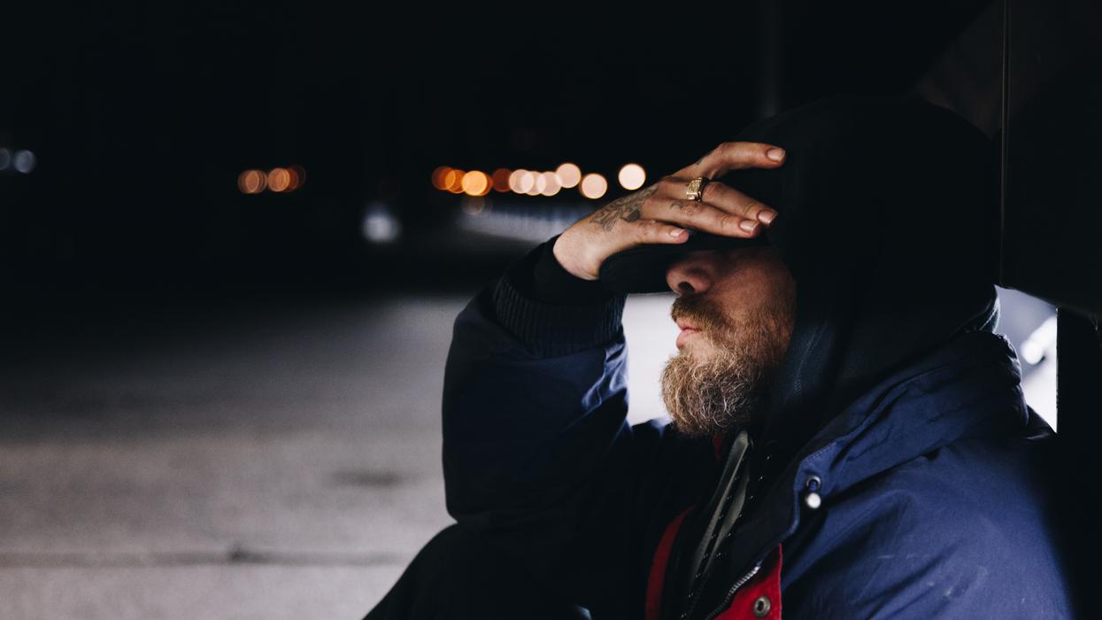 man sitting beside the street