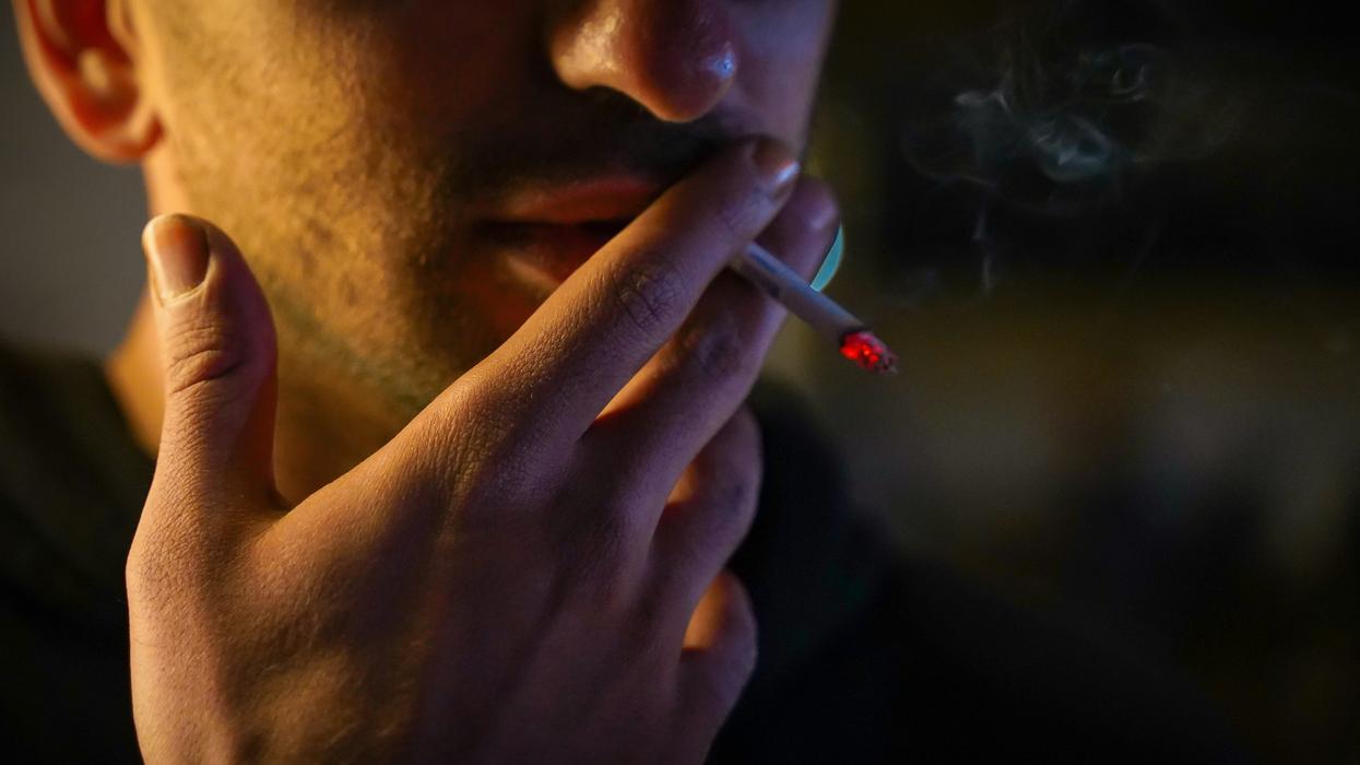 man smoking a cigarette in the dark