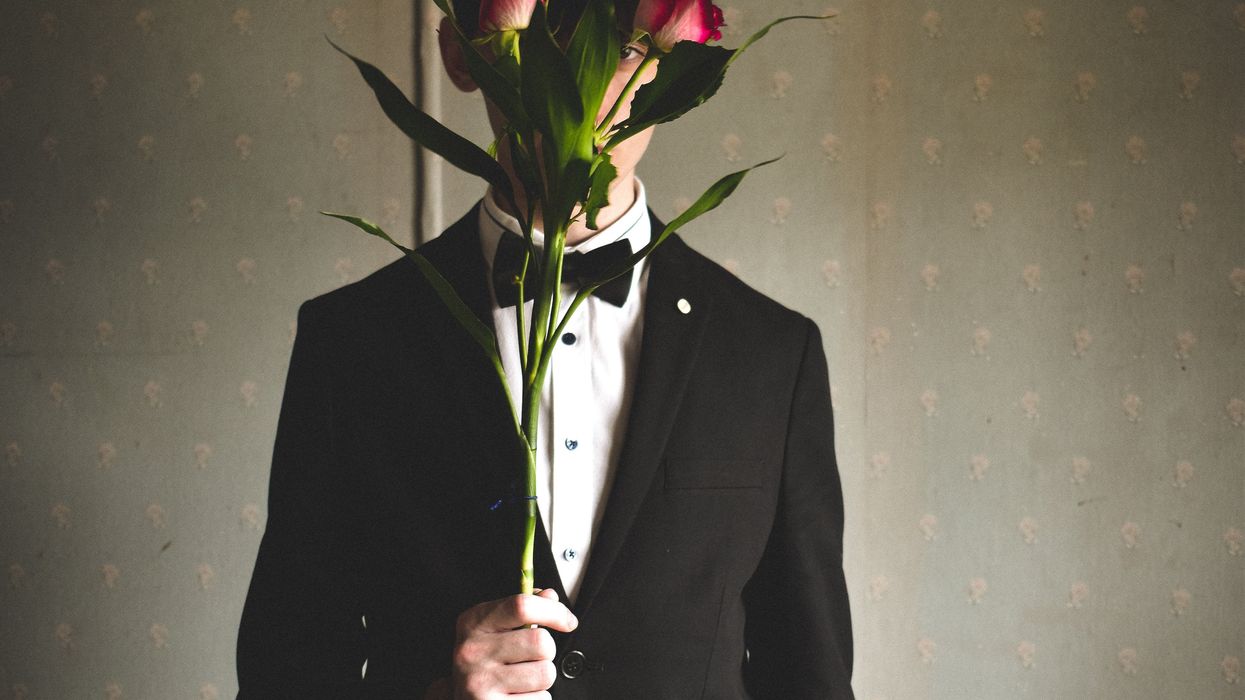 Man standing behind large flowers