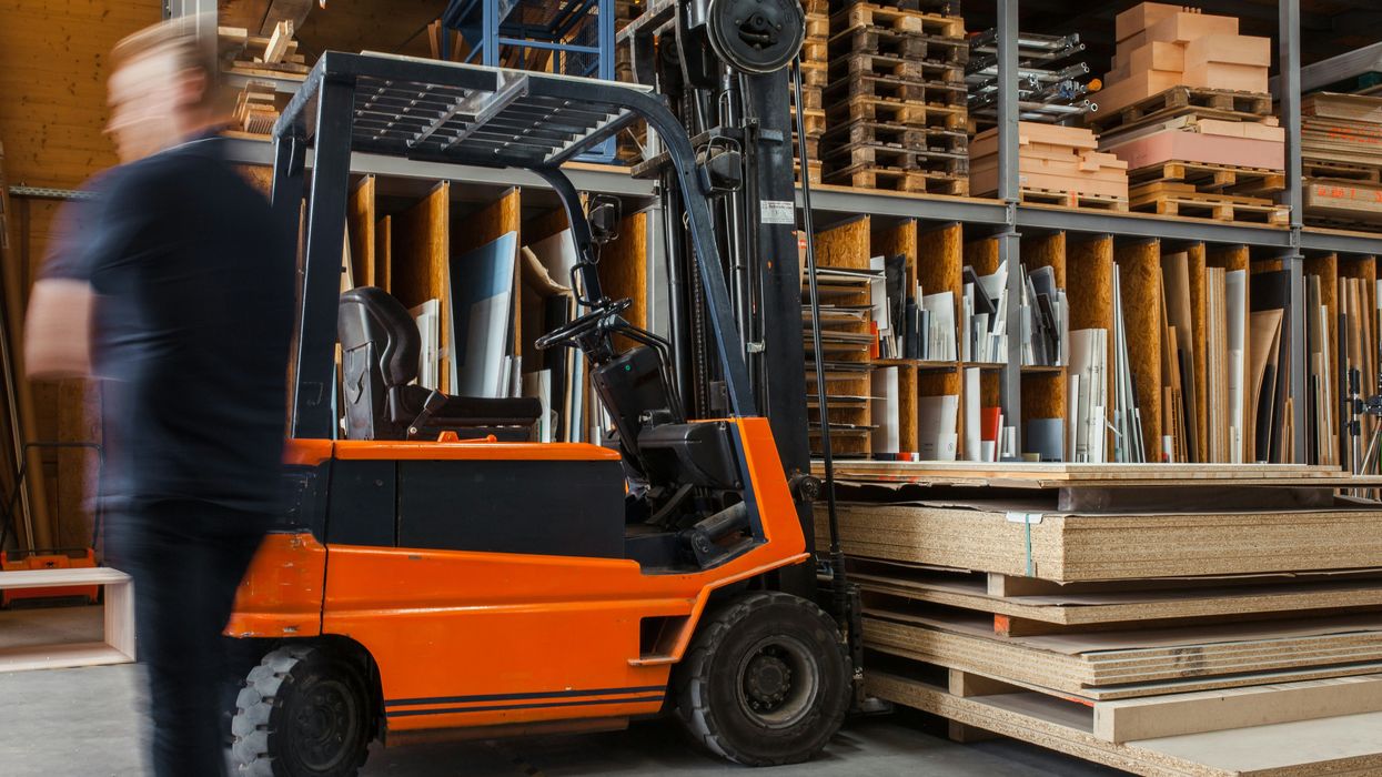 Man walking by warehouse forklift