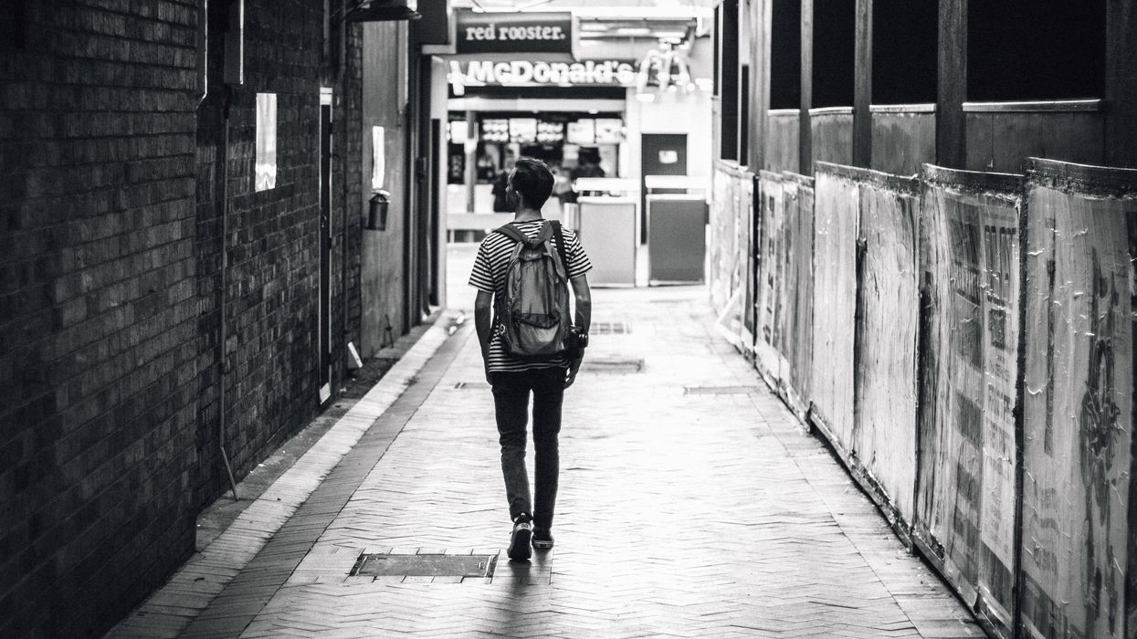 Man walking down alleyway in city