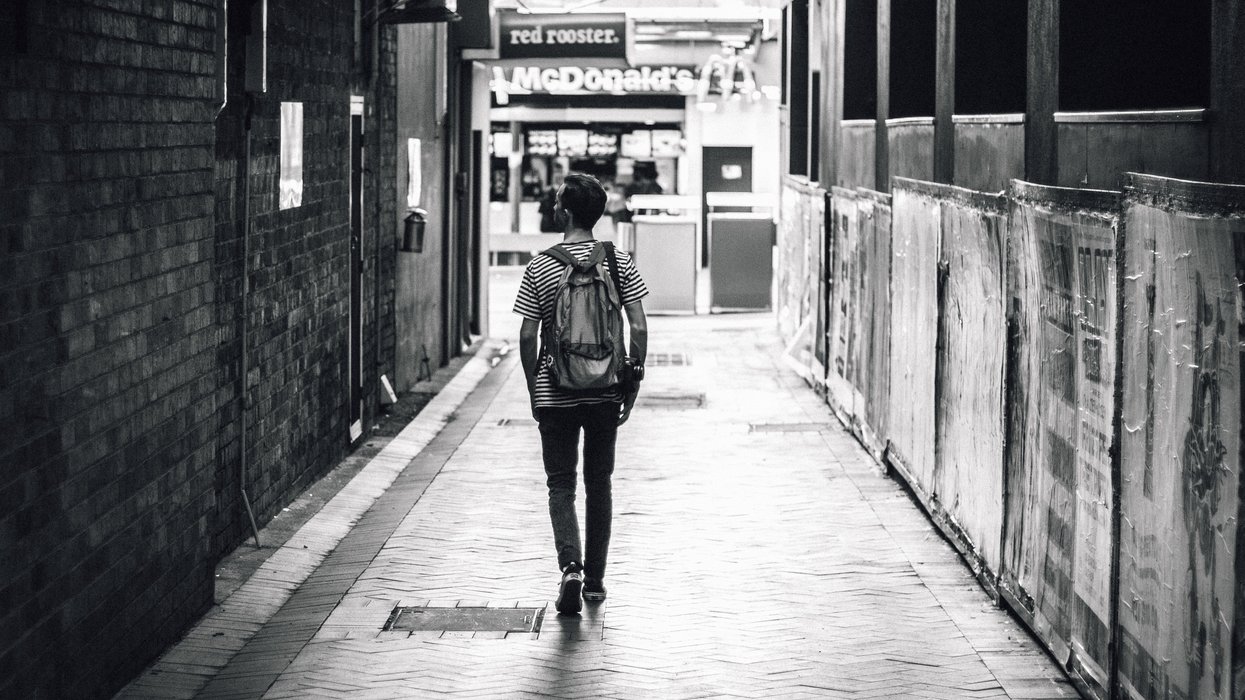 Man walking down alleyway in city