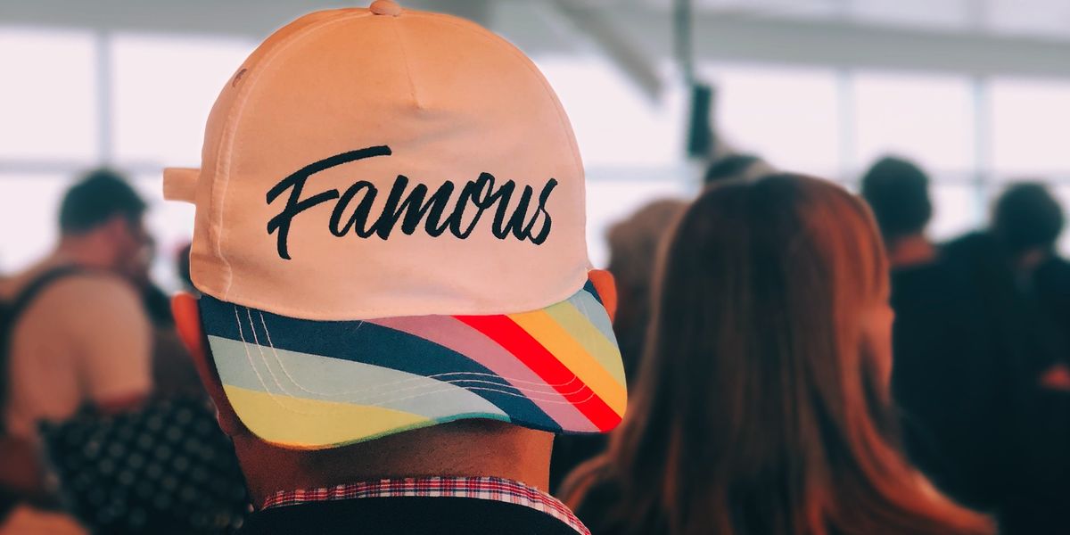 Man wearing a hat that says famous on it.