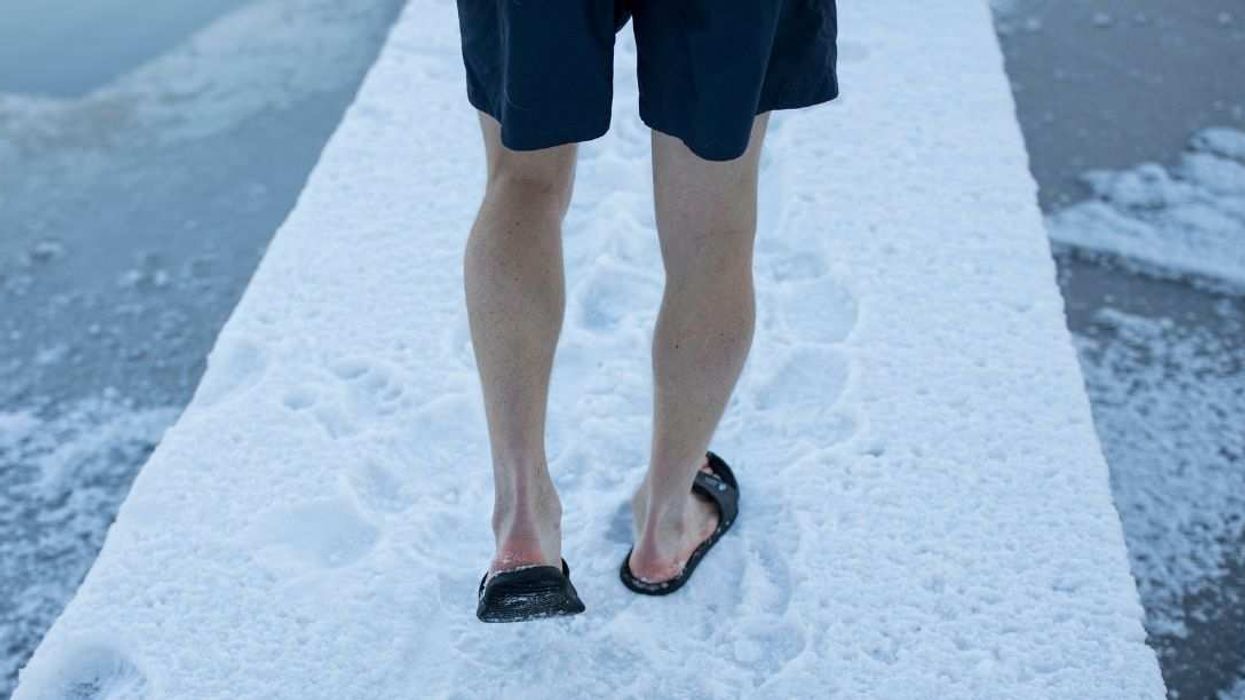 Man wearing shorts and flipflops in snow