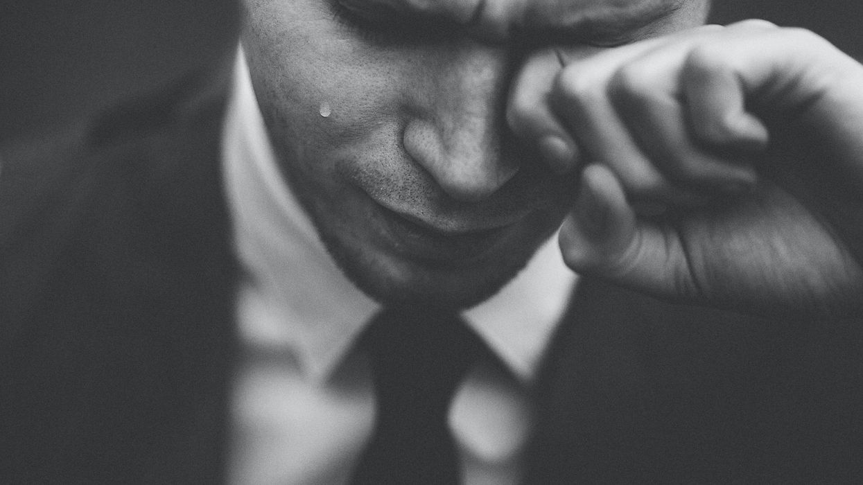 man wiping his tears