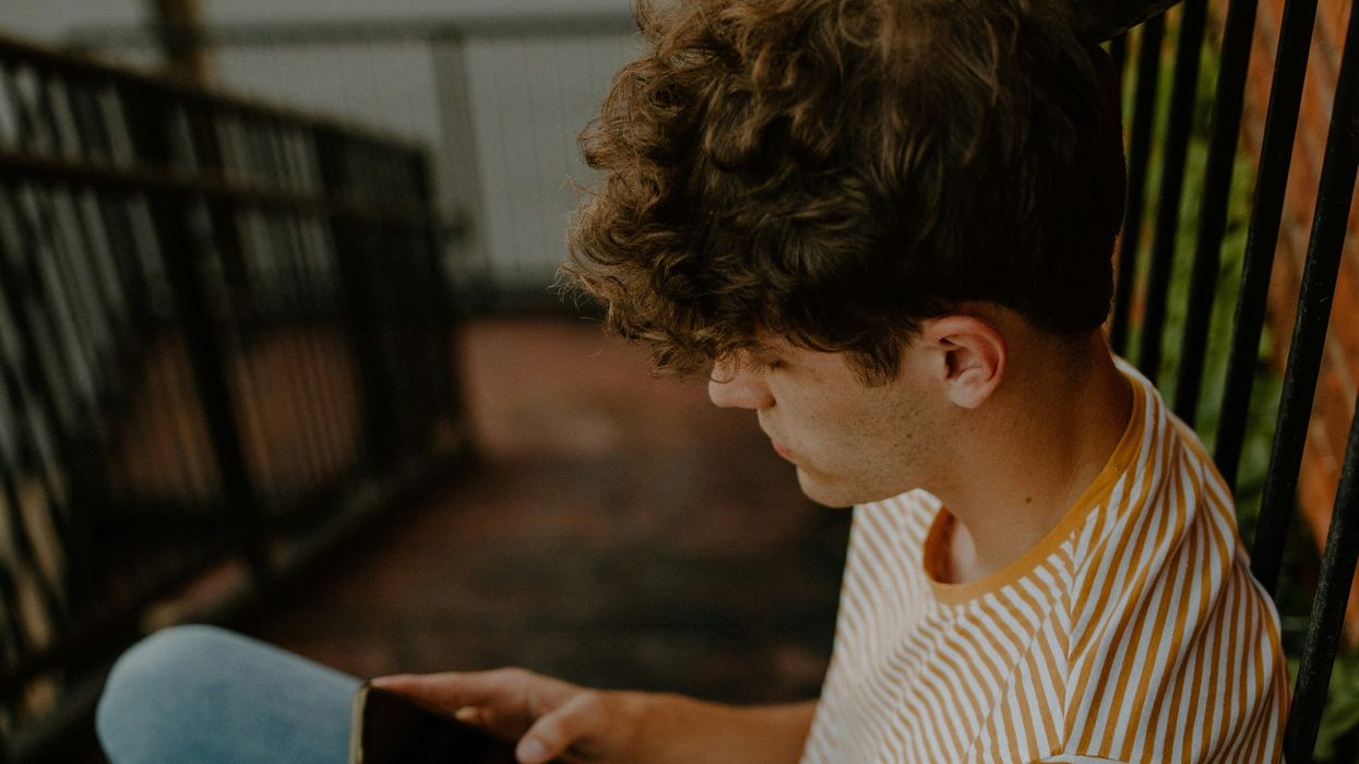 man with cellphone seated on stairs