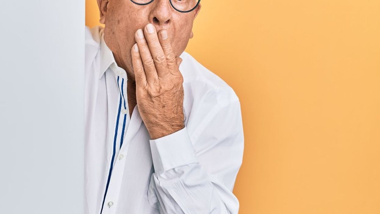 Man with hand covering mouth in shock