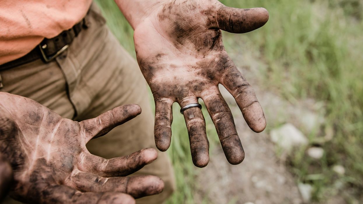 man with his hands covered with grime