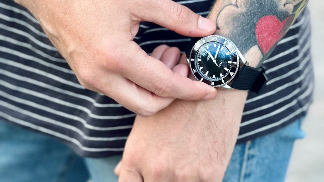 Man with tattoo showing off fancy watch