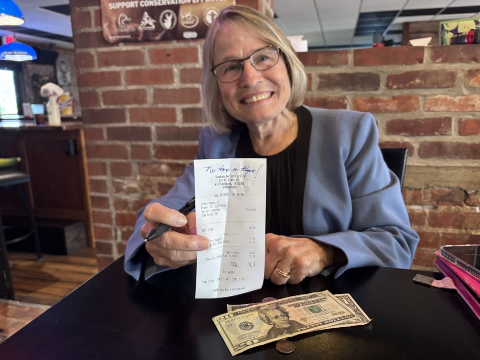 Mariannette Miller-Meeks holding up bill and showing off tip left for server