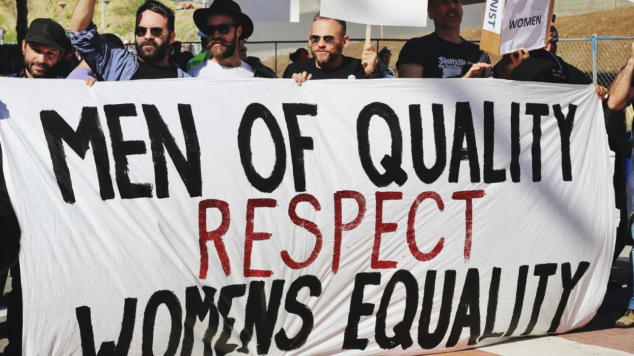 men holding white, black, and red 'Men of quality respect womens equality' banner