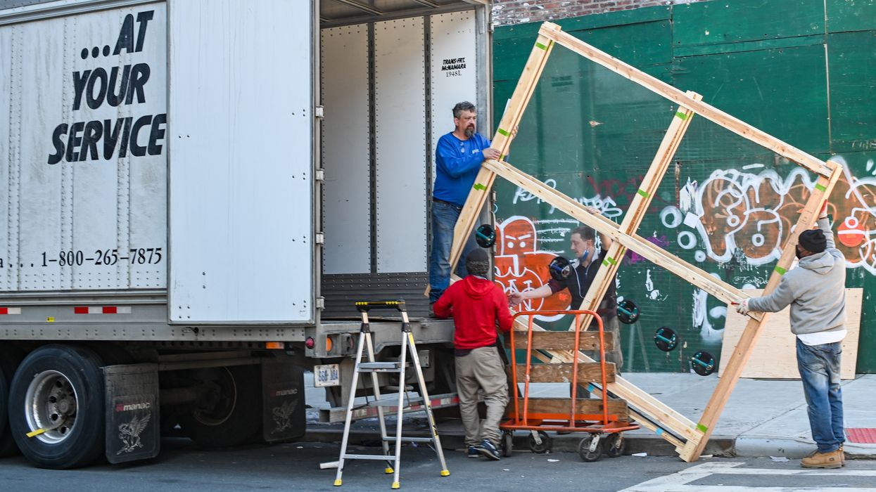 Men moving a window into a moving truck