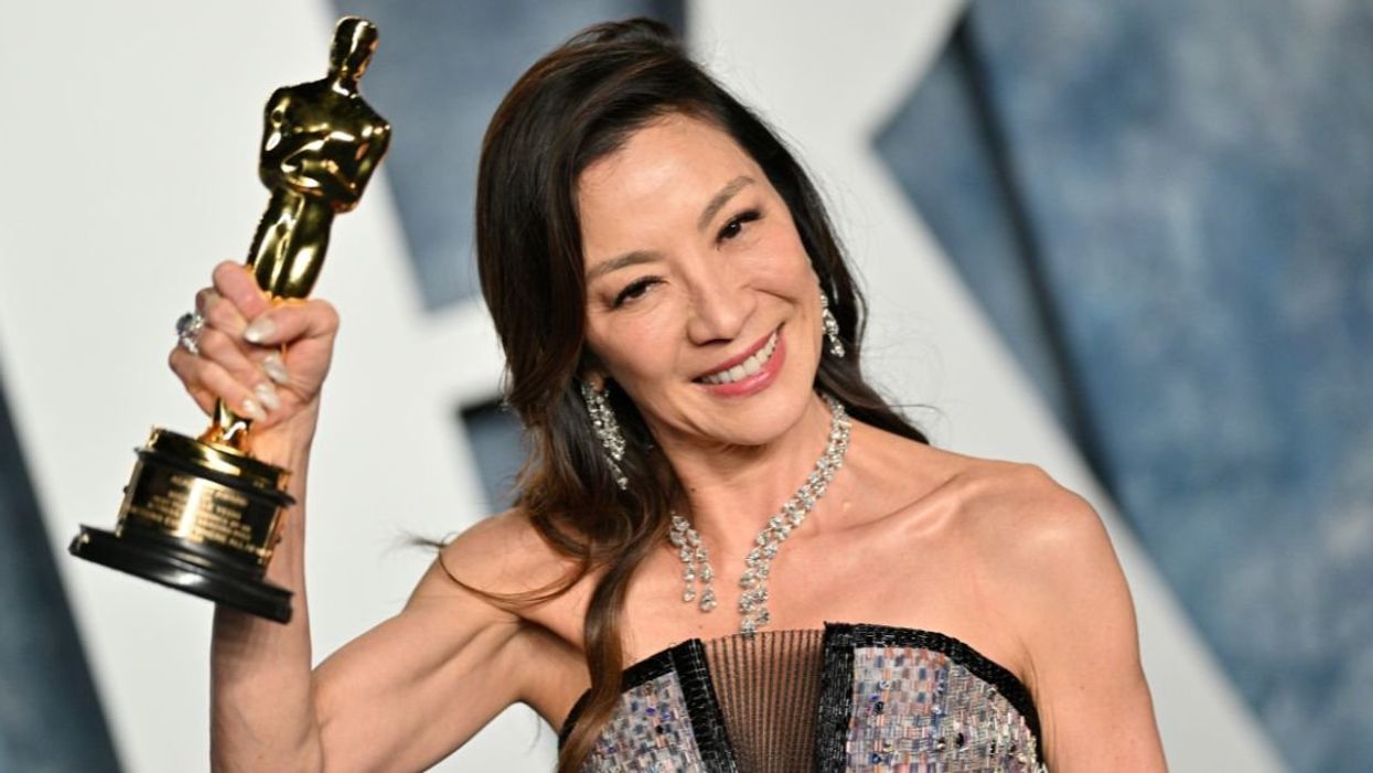 Michelle Yeoh holding her Oscar