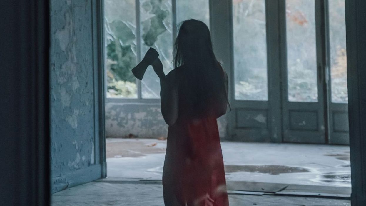 Mirror reflection of woman carrying an ax