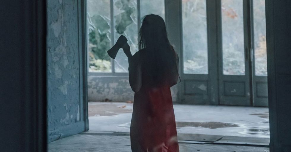 Mirror reflection of woman carrying an ax