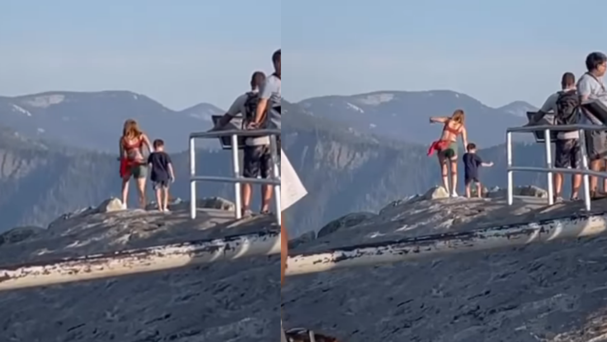 Mother and child cross safety railing for viewing area at national park