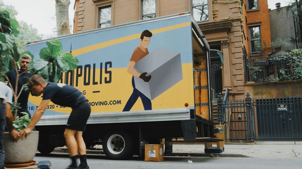 movers by yellow and blue moving truck