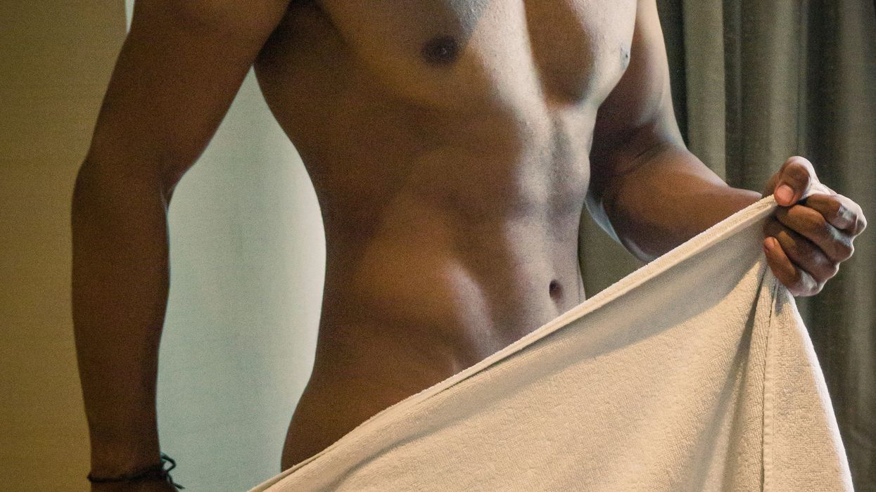 Naked male torso with a towel in front of him.
