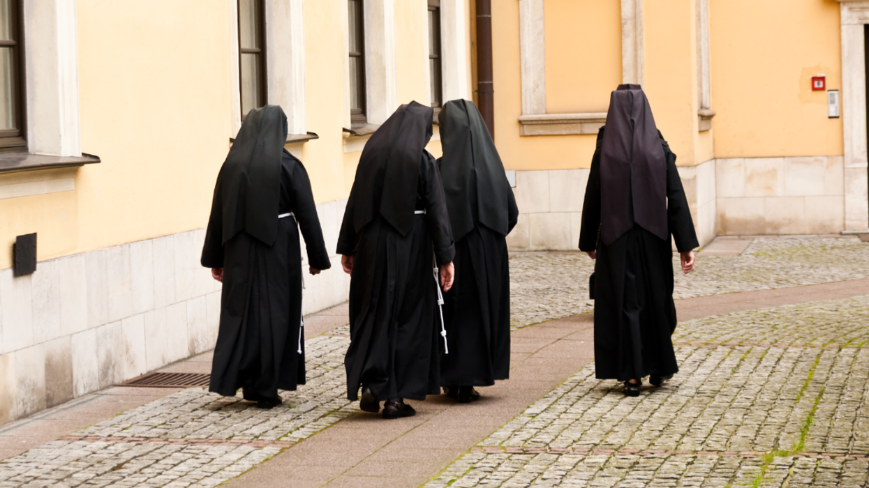 nuns walking down a cobblestone street