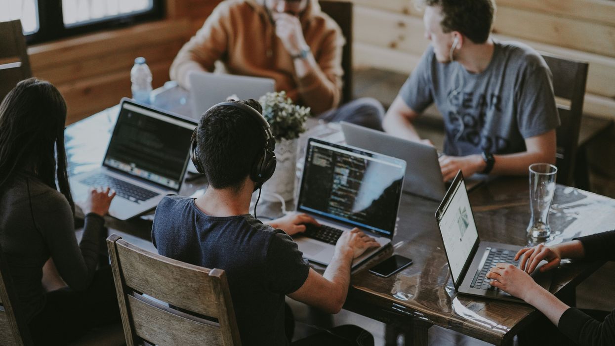 office workers on laptops seated at shared workspace