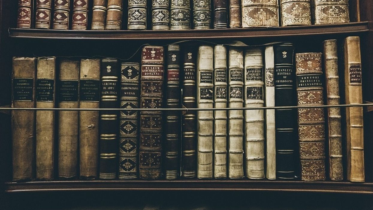 Old books sit on a library shelf