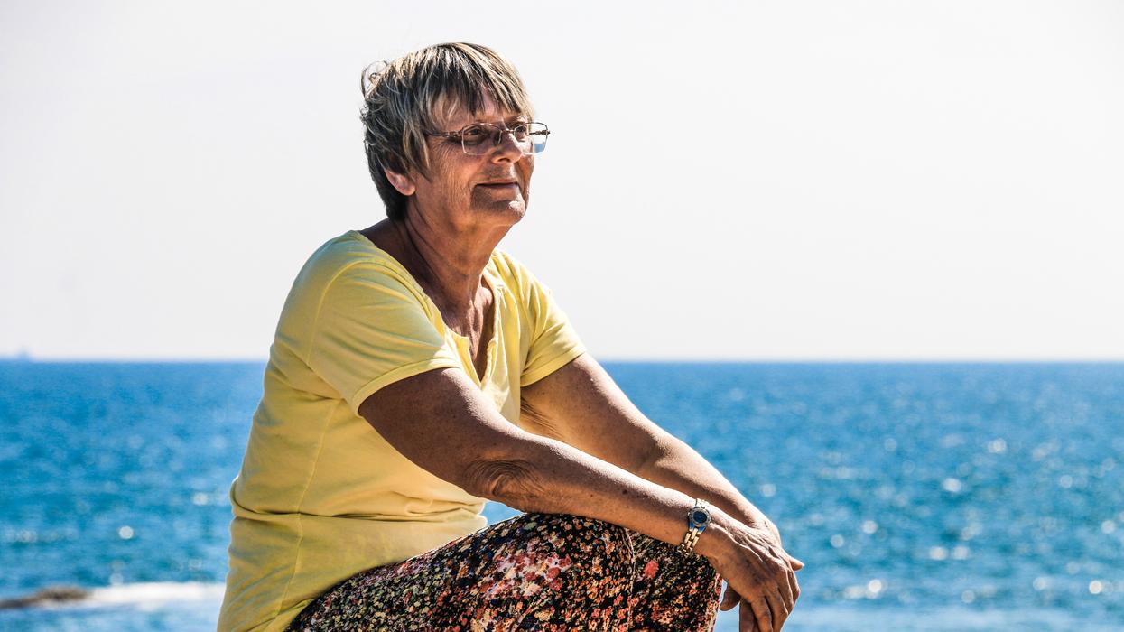 Older woman sitting outside, thinking