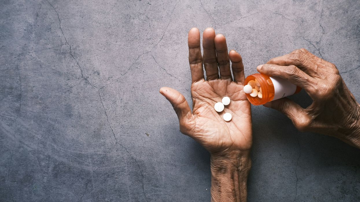 One hand pouring pills into another.