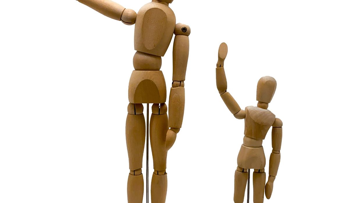 One tall wooden human figure next to shorter figure