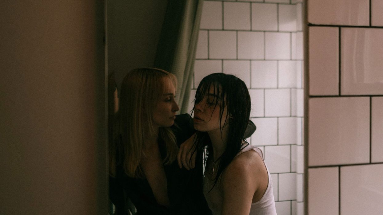 One woman props up another woman who seems inebriated