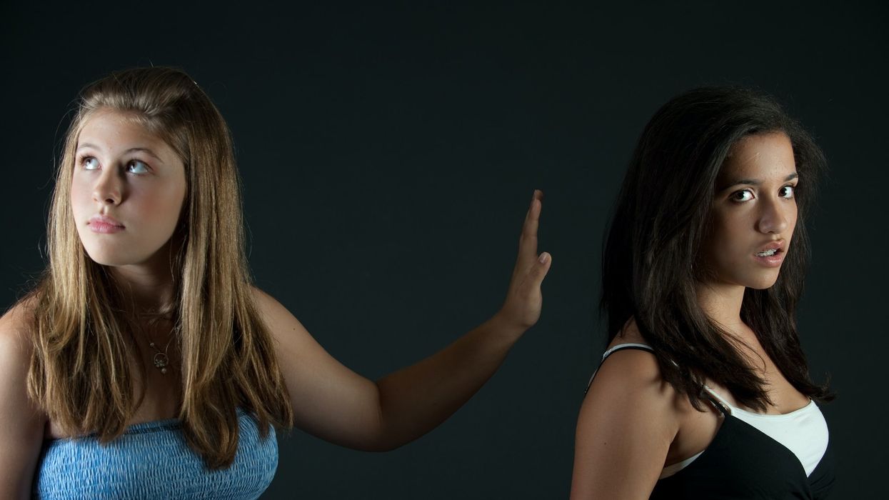 One woman refuses to look another in the face, so she puts her hand up between them