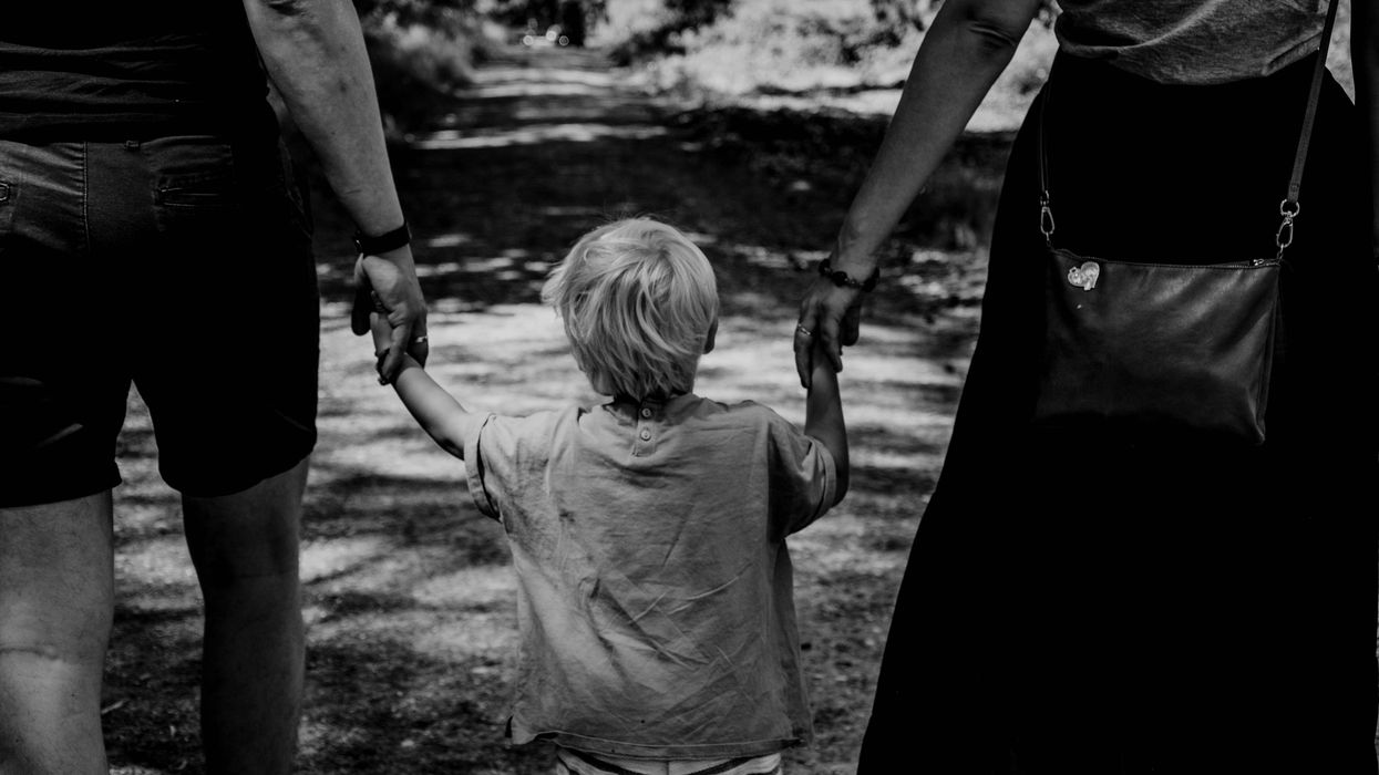 parents holding child's hands