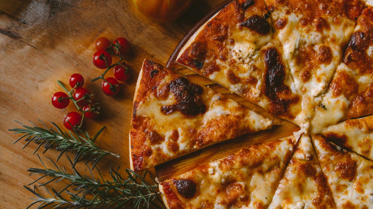 Parsley sprigs and red berries next to cheese pizza