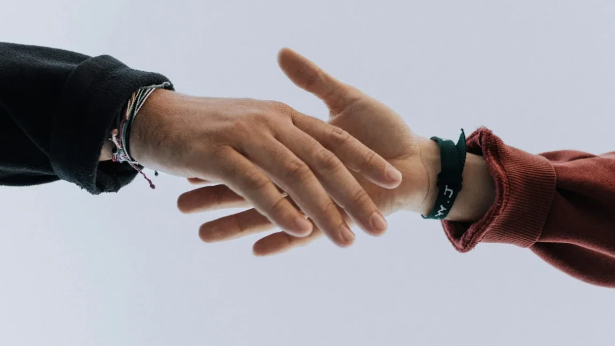 people reaching to shake hands