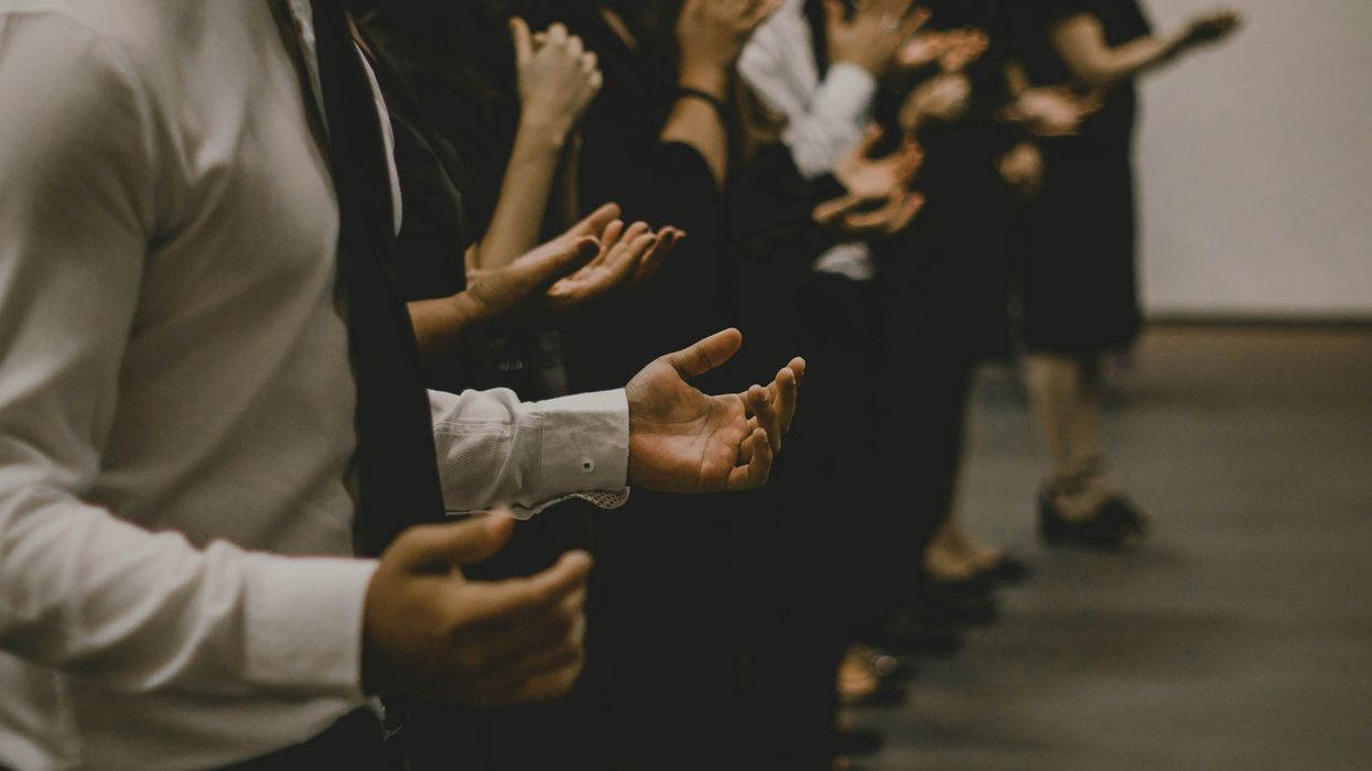 people with palms raised in religious service