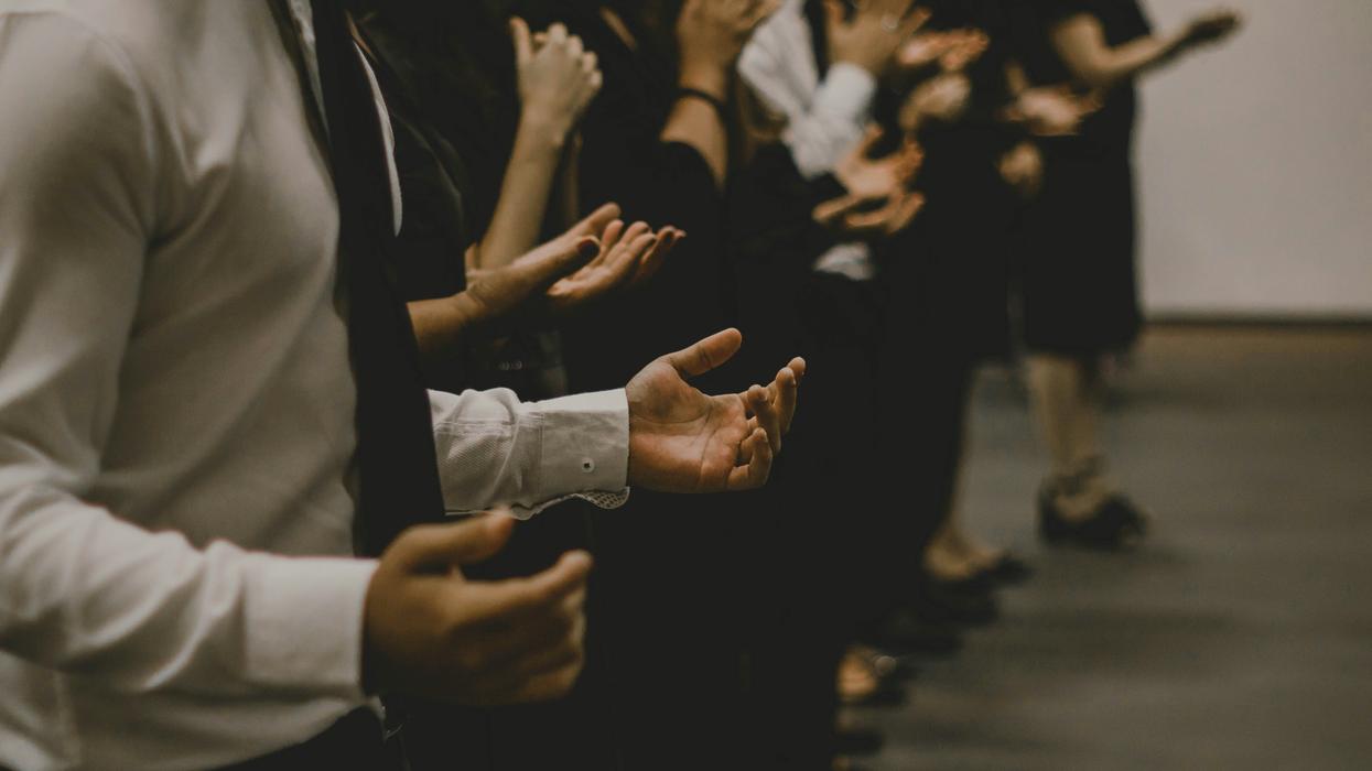 people with palms raised in religious service