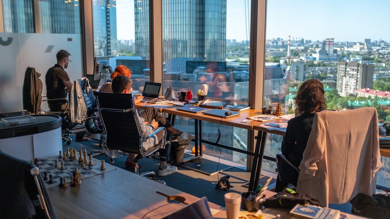 People working at a desk by the window.