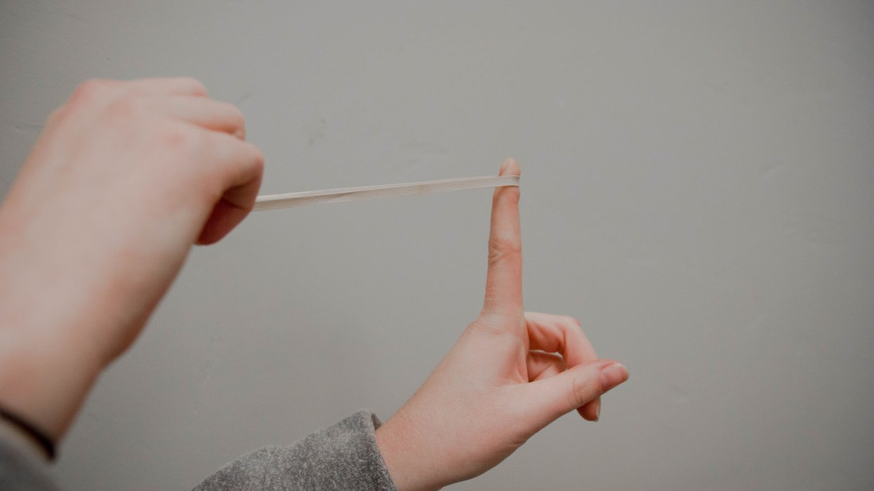 Person about to fling stretched rubber band