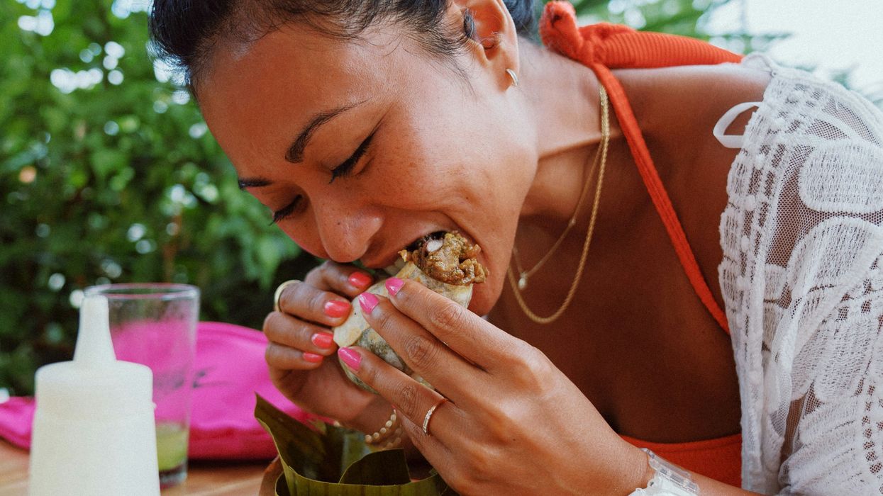 Person biting into a sandwich wrap