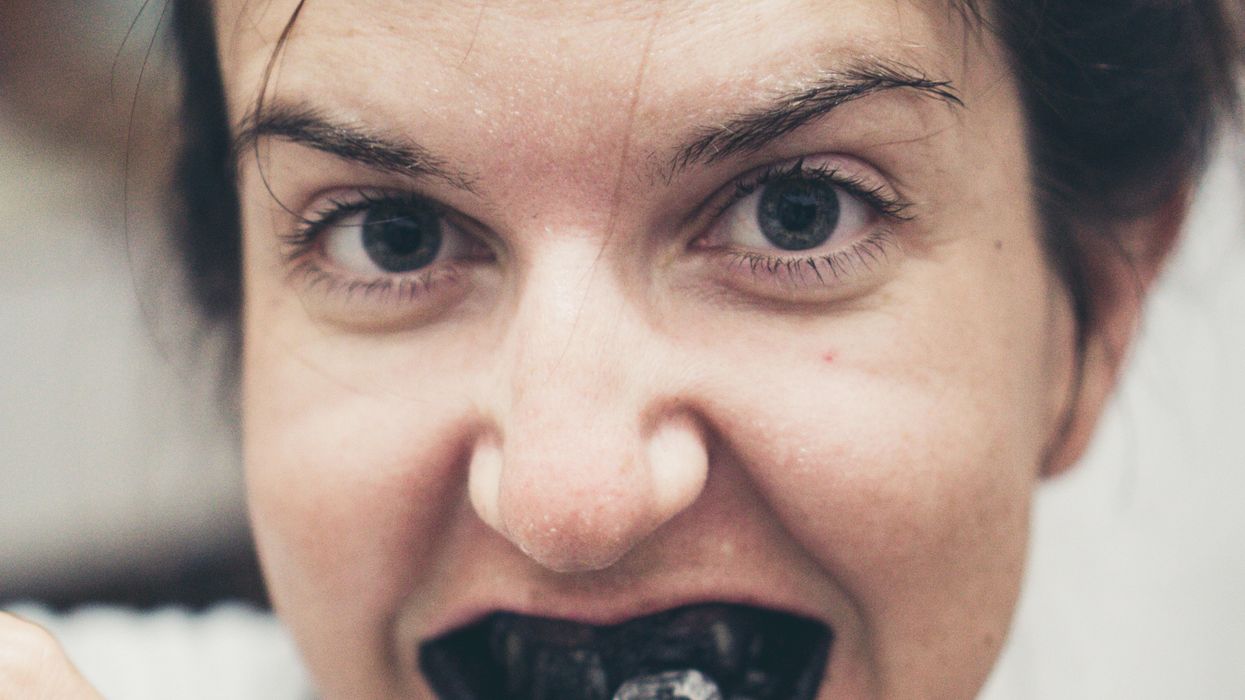 Person brushing with charcoal toothpaste