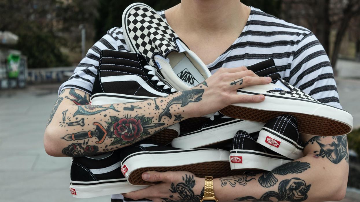 Person carrying an armload of new Vans shoes