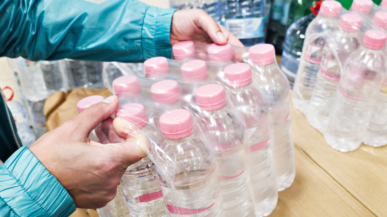 Person carrying cases of water bottles