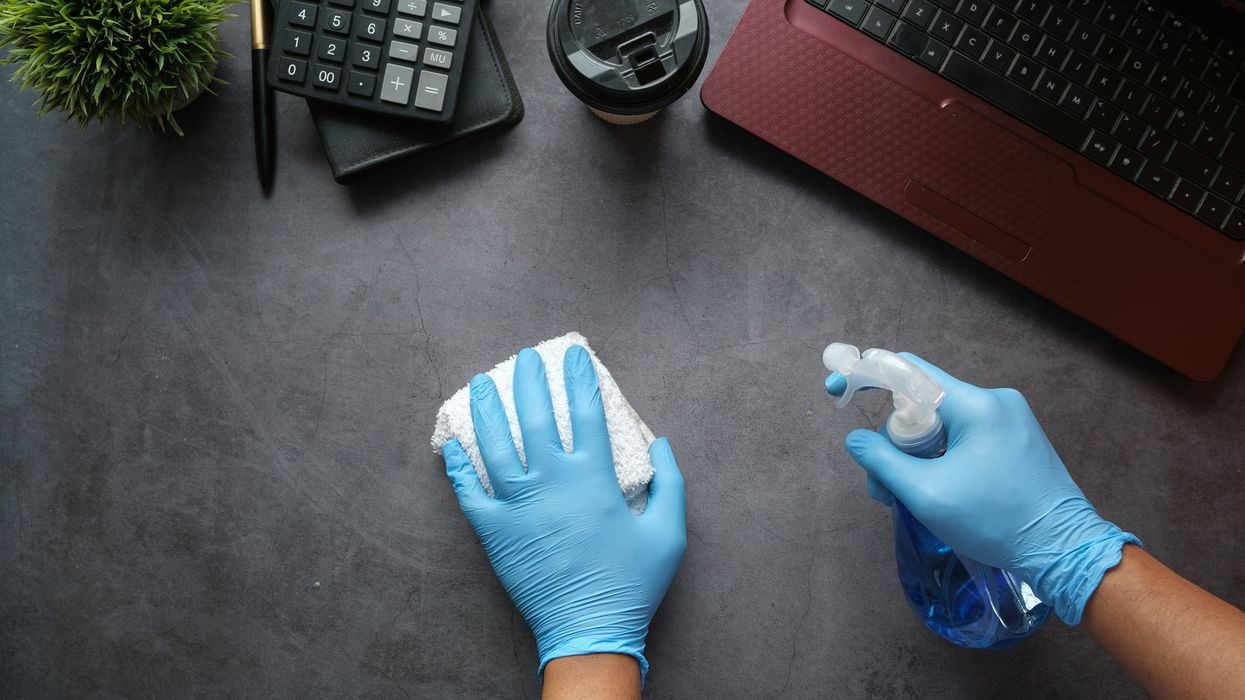 Person cleaning around their desk