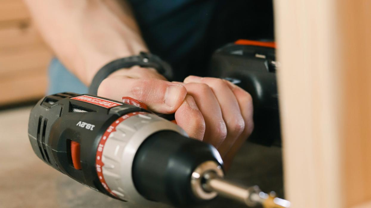 Person completing a repair with an electric drill