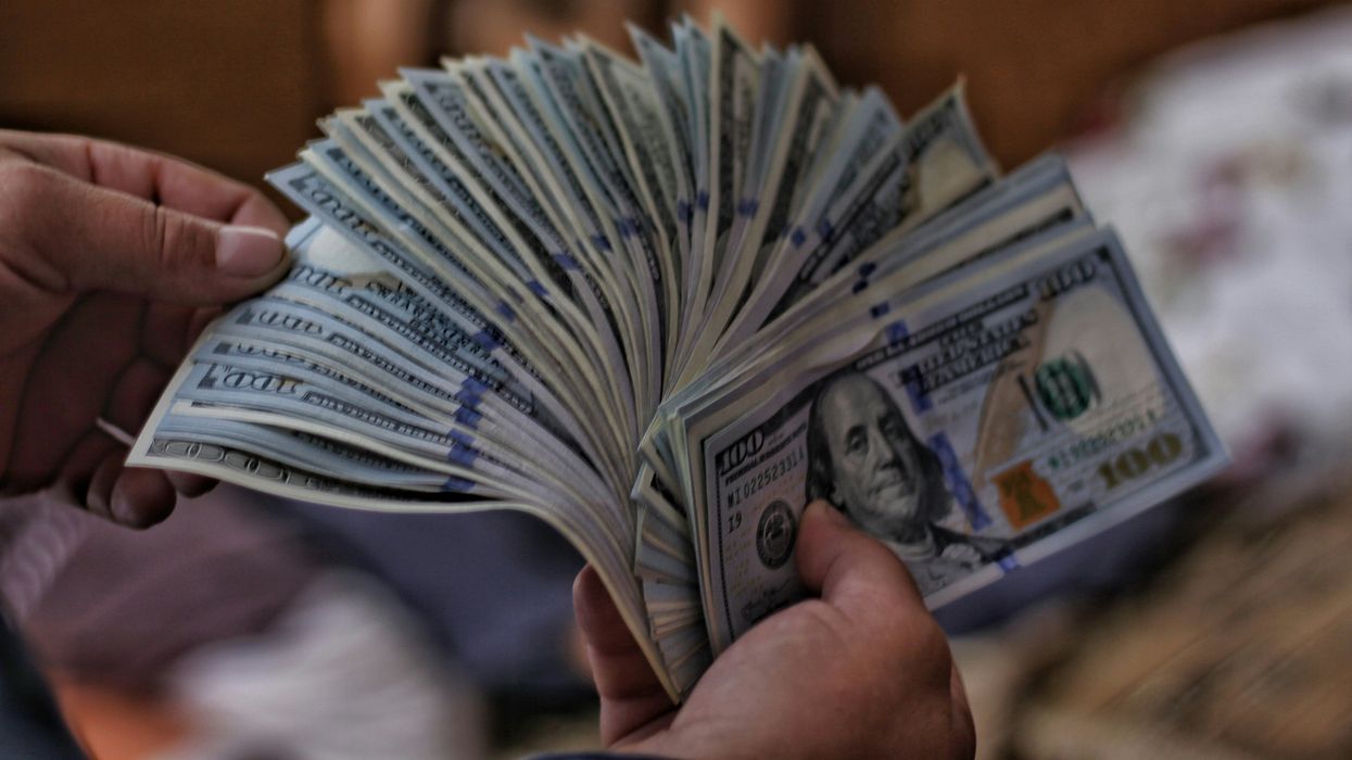 Person counting $100 U.S. bills