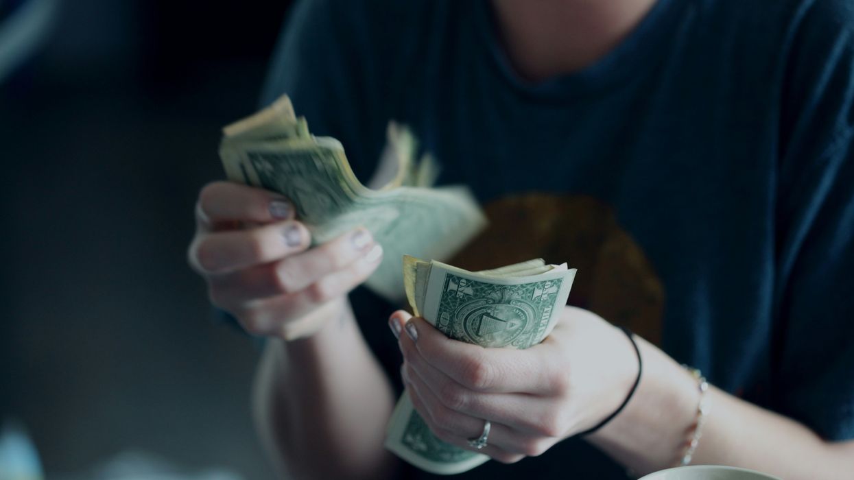 person counting dollar banknotes