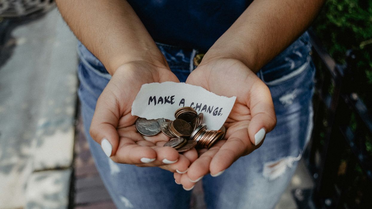 person cupping both hands with 'make a change' note and coins